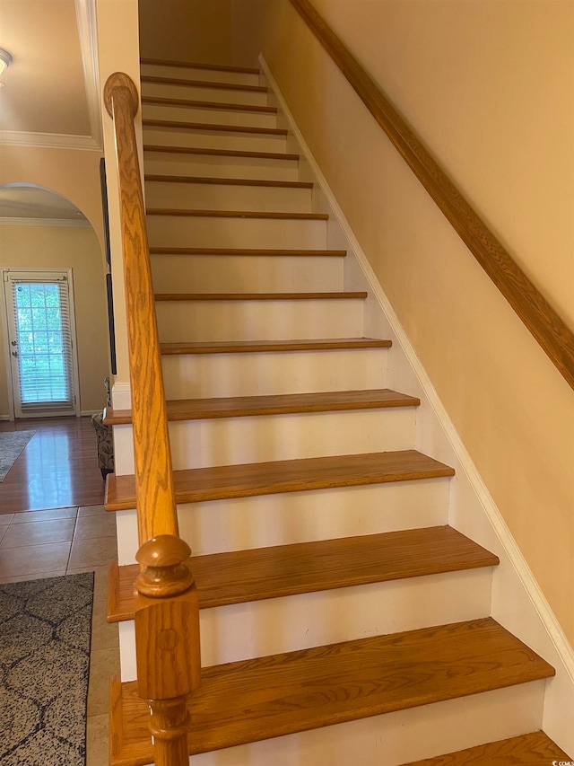 staircase featuring tile patterned flooring and ornamental molding