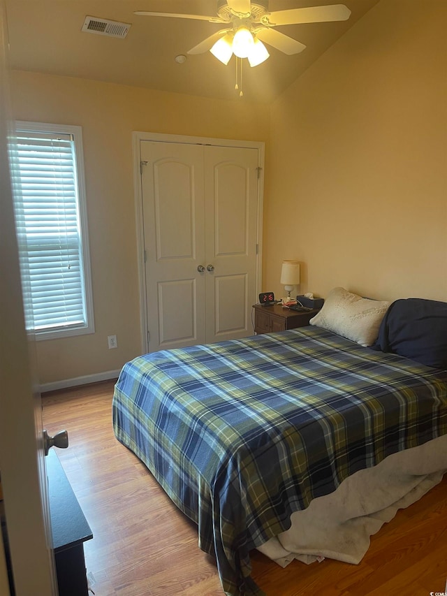 bedroom with a closet, ceiling fan, vaulted ceiling, and light wood-type flooring