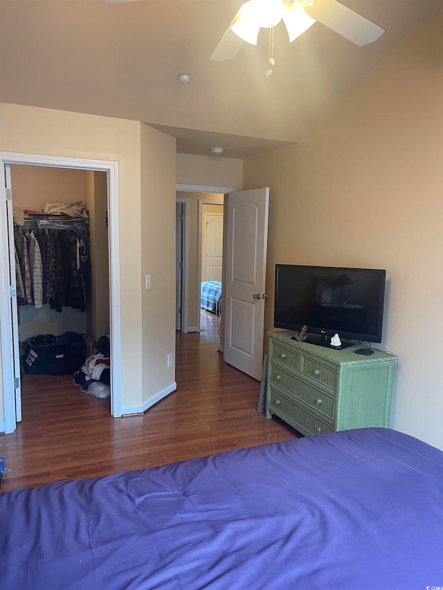 unfurnished bedroom with ceiling fan, vaulted ceiling, a closet, and dark hardwood / wood-style flooring