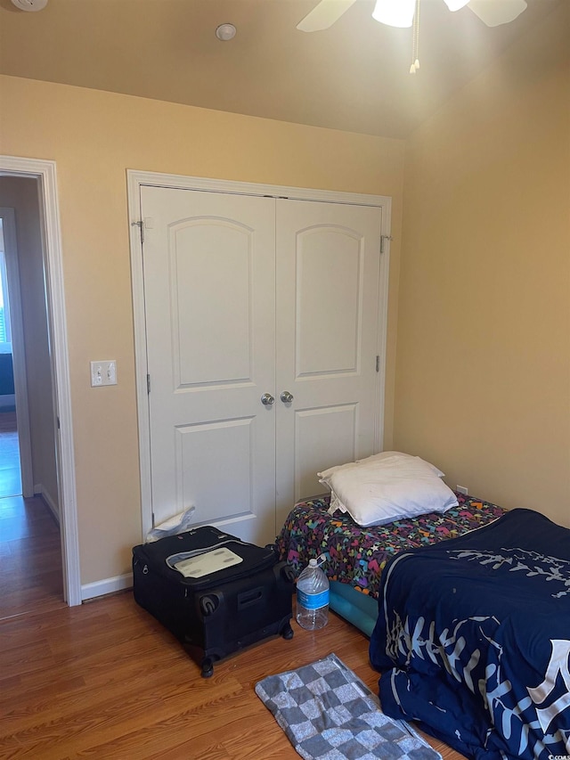 bedroom with ceiling fan, wood-type flooring, and a closet