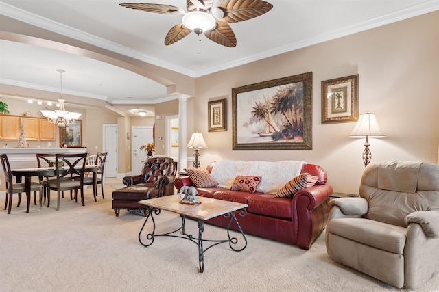 living room featuring crown molding, ceiling fan with notable chandelier, light carpet, and decorative columns