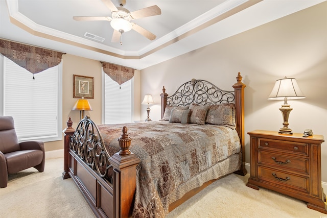 bedroom with crown molding, a raised ceiling, light colored carpet, and ceiling fan