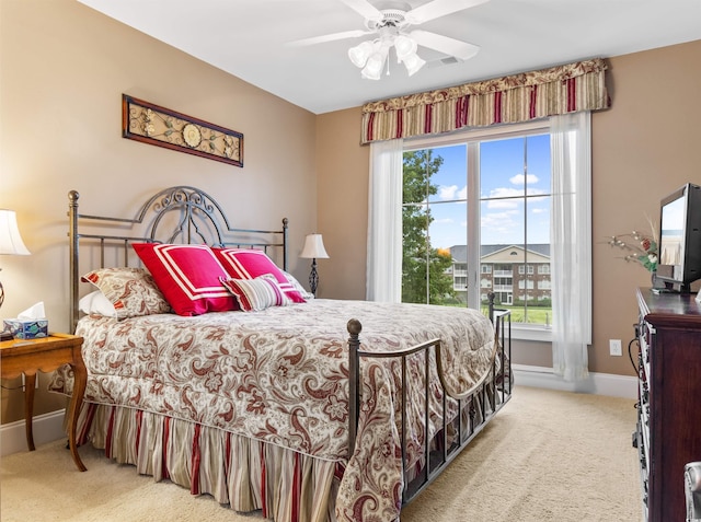 carpeted bedroom featuring ceiling fan and multiple windows