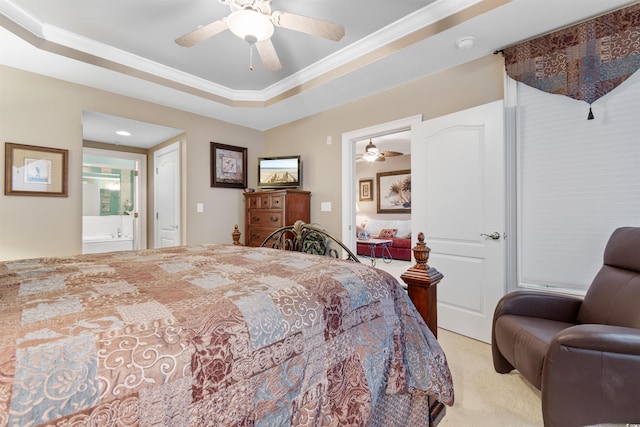 bedroom featuring a raised ceiling, crown molding, connected bathroom, light colored carpet, and ceiling fan