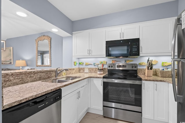 kitchen with light wood-type flooring, stainless steel appliances, white cabinetry, and sink