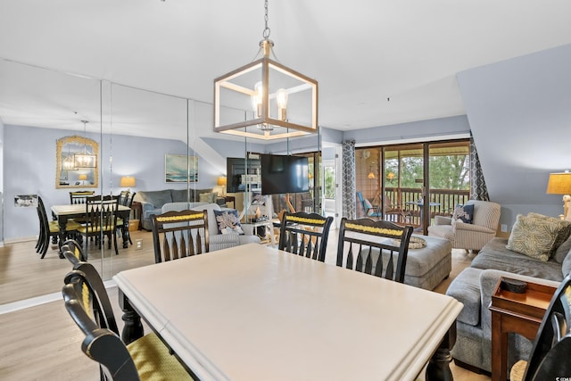 dining area featuring light hardwood / wood-style flooring and an inviting chandelier