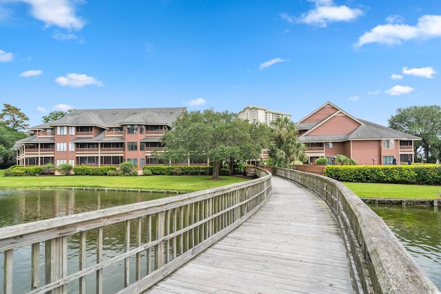 view of dock featuring a water view and a lawn