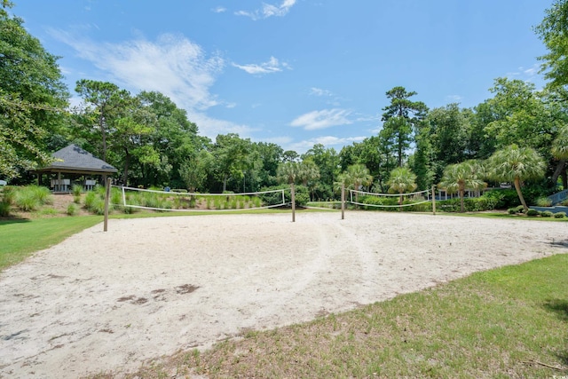 surrounding community with volleyball court, a lawn, and a gazebo