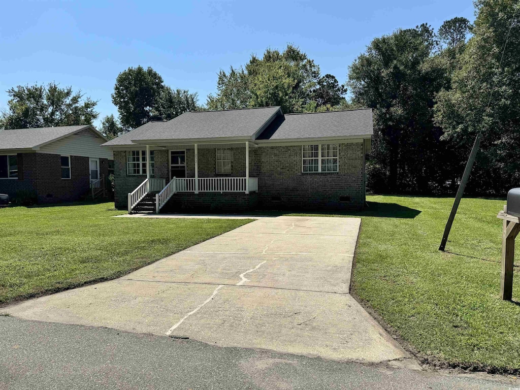 ranch-style home with concrete driveway, crawl space, covered porch, a front yard, and brick siding