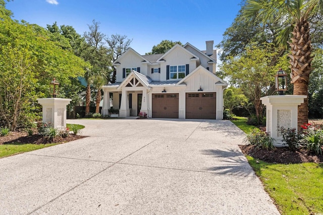 405 N Highland Way, Myrtle Beach, SC 29572 - view of front of house featuring board and batten siding, a garage, concrete driveway, a standing seam roof, and a chimney