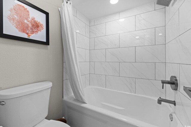 bathroom with toilet and shower / bath combo with shower curtain