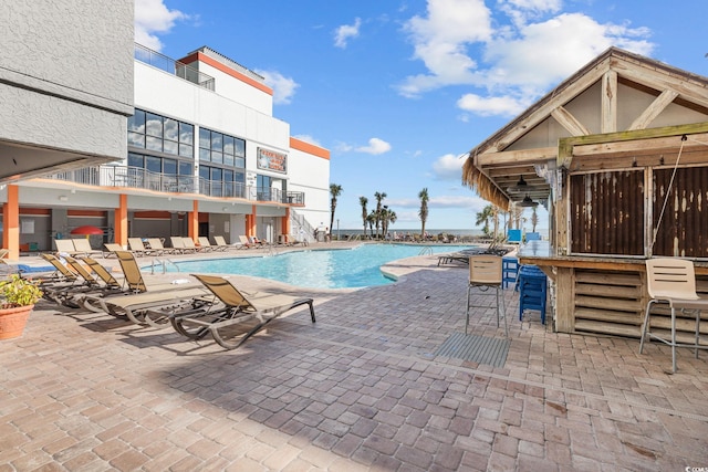 view of swimming pool with a bar and a patio area