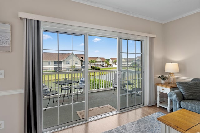 entryway with plenty of natural light, ornamental molding, and hardwood / wood-style flooring