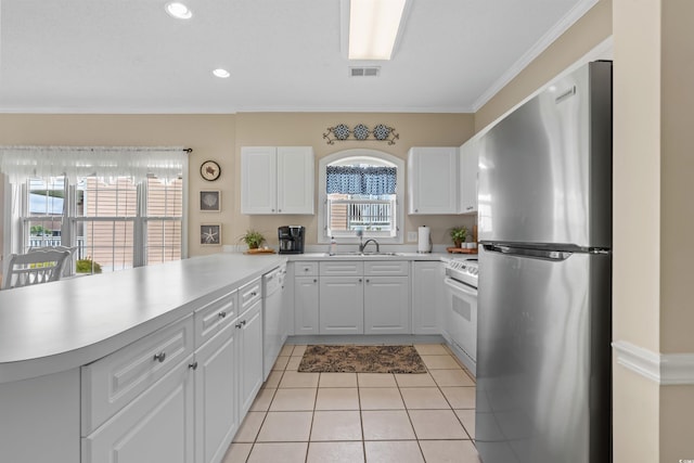 kitchen with white appliances, ornamental molding, white cabinets, and light tile patterned floors