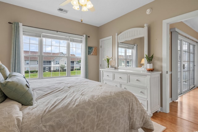 bedroom featuring light hardwood / wood-style flooring, ceiling fan, and multiple windows