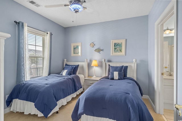 bedroom with ceiling fan, ensuite bathroom, a textured ceiling, and light tile patterned floors