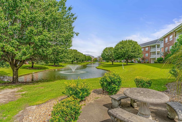 view of property's community featuring a yard and a water view