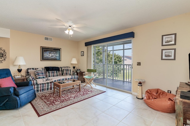 tiled living room with ceiling fan and a textured ceiling