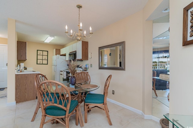 dining space with sink, a textured ceiling, a chandelier, and light tile patterned floors