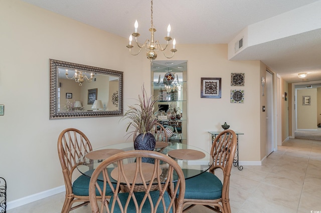 dining area with a textured ceiling and a notable chandelier