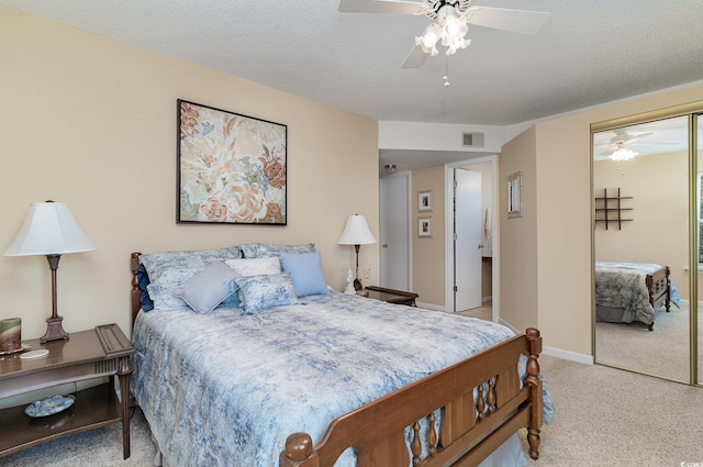 bedroom featuring light carpet, a closet, ceiling fan, and a textured ceiling