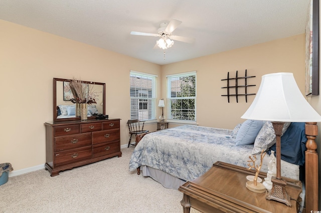 bedroom featuring a textured ceiling, ceiling fan, and light colored carpet