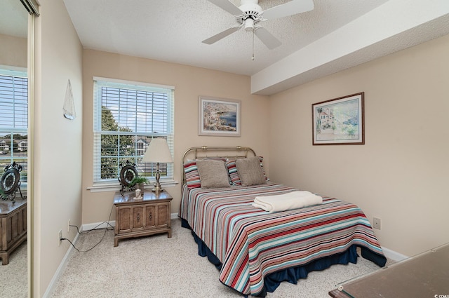 bedroom featuring ceiling fan, a textured ceiling, and light colored carpet