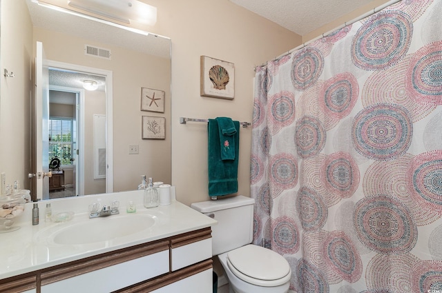 bathroom featuring toilet, a textured ceiling, and vanity