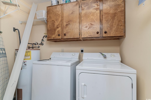 washroom with washer and dryer, water heater, and cabinets