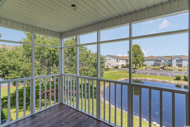 unfurnished sunroom featuring a water view