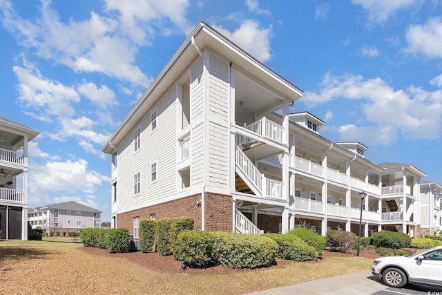 view of home's exterior featuring uncovered parking and brick siding