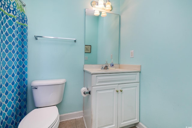 bathroom with toilet, vanity, and tile patterned floors