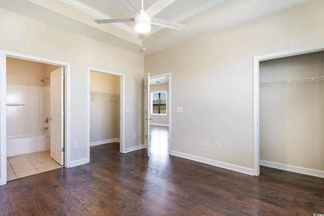 unfurnished bedroom featuring baseboards, a closet, wood finished floors, and ensuite bath