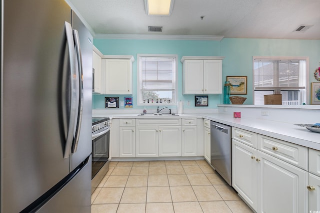 kitchen featuring white cabinets, sink, appliances with stainless steel finishes, and light tile patterned flooring