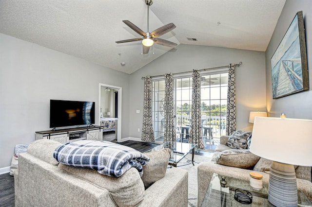 living room with ceiling fan, lofted ceiling, a textured ceiling, and wood-type flooring