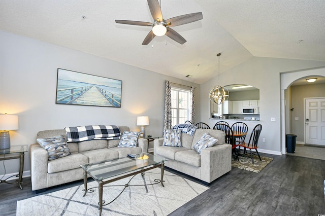 living room with hardwood / wood-style flooring, a textured ceiling, ceiling fan with notable chandelier, and lofted ceiling