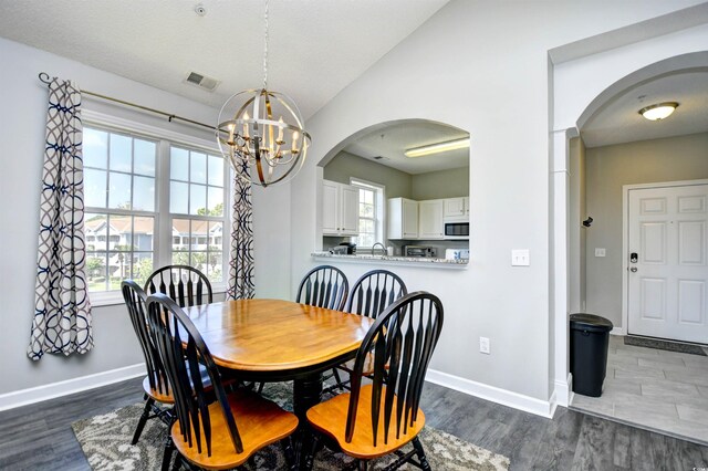 5801 Oyster Catcher Dr Unit 434, North Myrtle Beach, SC 29582 - dining room featuring arched walkways, a chandelier, and dark wood-style flooring