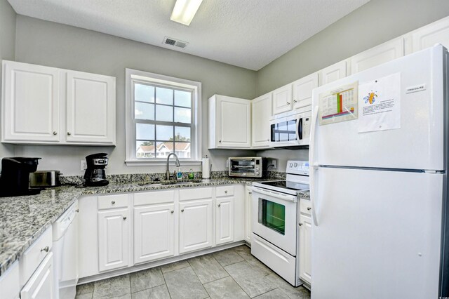 5801 Oyster Catcher Dr Unit 434, North Myrtle Beach, SC 29582 - kitchen with white appliances, white cabinetry, light stone counters, and a textured ceiling