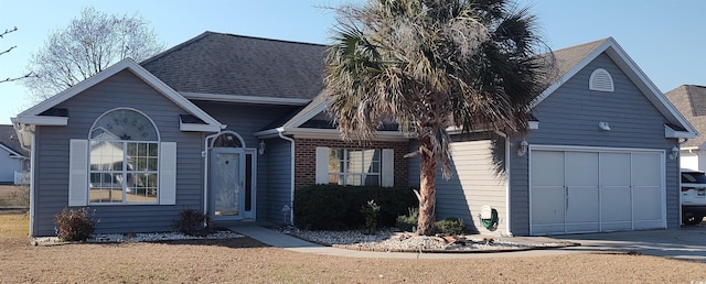 view of front facade featuring driveway, a shingled roof, and an attached garage