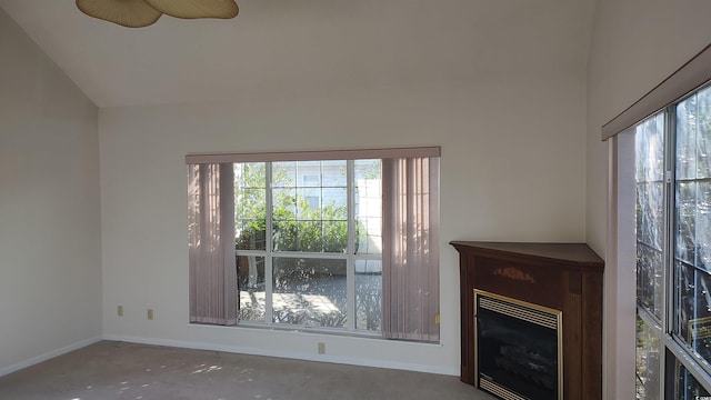 unfurnished living room featuring vaulted ceiling, concrete floors, a fireplace, and baseboards