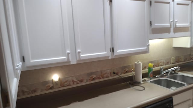 kitchen with backsplash, a sink, and white cabinets