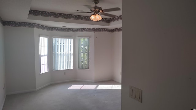 carpeted empty room with ceiling fan, visible vents, and baseboards