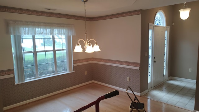 foyer with baseboards, light wood-style floors, visible vents, and wallpapered walls