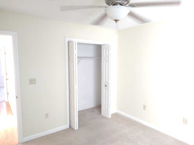 unfurnished bedroom with a ceiling fan, baseboards, a closet, and light colored carpet