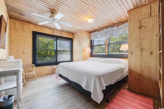 bedroom with wood ceiling, hardwood / wood-style floors, and multiple windows