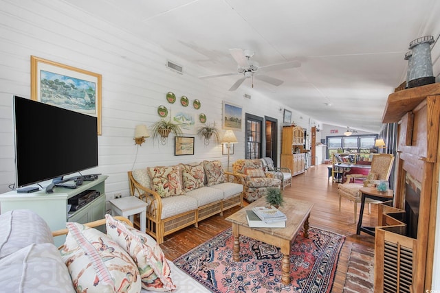 living room with vaulted ceiling, hardwood / wood-style floors, and ceiling fan