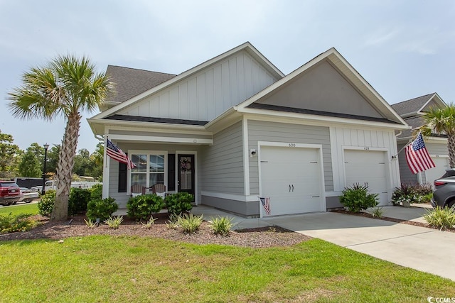 view of front of house featuring a porch, a garage, and a front yard