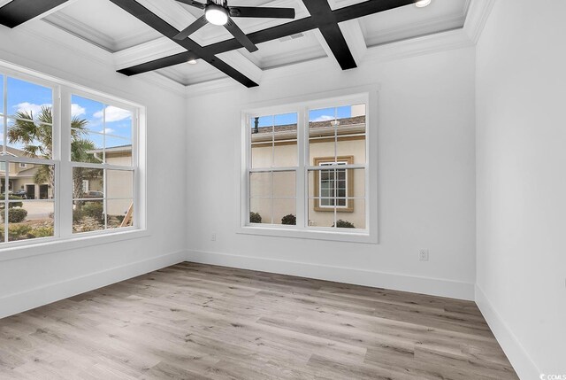 spare room with beam ceiling, coffered ceiling, and light hardwood / wood-style floors