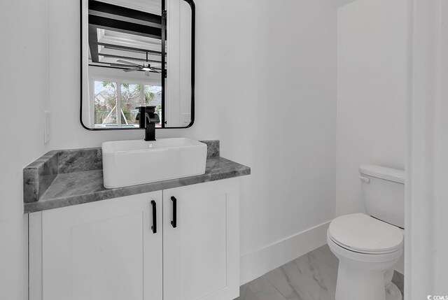 bathroom featuring vanity, ceiling fan, and toilet