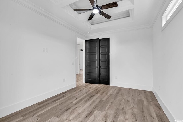 empty room featuring a tray ceiling, ornamental molding, light hardwood / wood-style floors, and ceiling fan